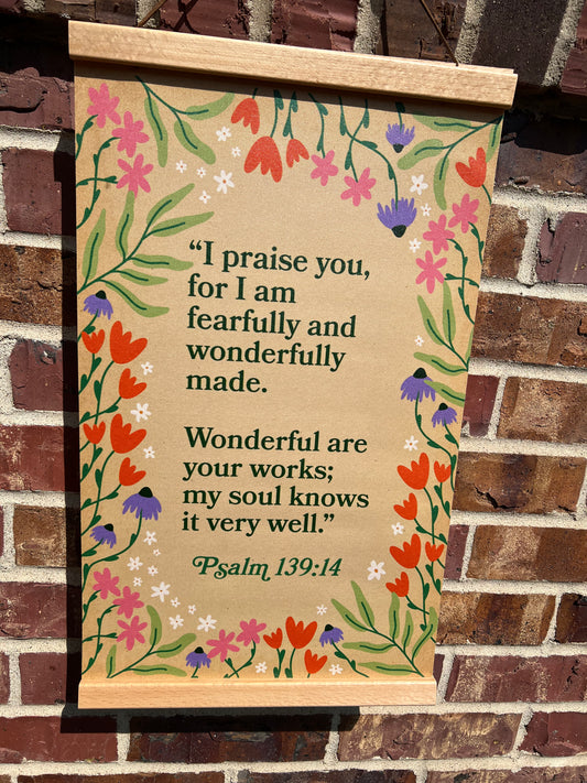 Decorative sign with floral design and Psalm 139:14 text on a brick wall background